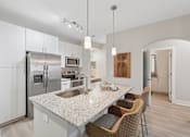 Thumbnail 14 of 26 - A modern kitchen with a granite countertop and stainless steel appliances.