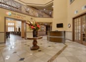Thumbnail 2 of 13 - the lobby of a hotel with a reception desk and a vase of flowers
