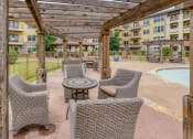 Thumbnail 10 of 13 - a patio with wicker chairs and a table next to a pool