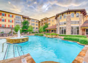 Thumbnail 9 of 13 - a swimming pool with a fountain in front of an apartment building