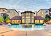 Thumbnail 11 of 13 - a swimming pool with a fountain in front of an apartment building