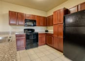 Thumbnail 4 of 13 - a kitchen with black appliances and wood cabinets