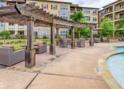 Thumbnail 8 of 13 - a pool area with chairs and umbrellas next to a building