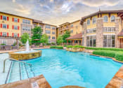 Thumbnail 7 of 13 - a swimming pool at a hotel with a wave in the water