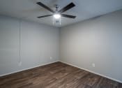 Thumbnail 8 of 26 - a bedroom with a ceiling fan and hardwood floors