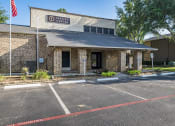 Thumbnail 24 of 26 - a brick building with a parking lot in front of it