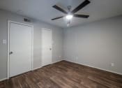 Thumbnail 7 of 26 - a bedroom with hardwood floors and a ceiling fan