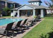 Thumbnail 23 of 26 - a pool with chairs in front of a building