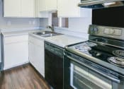 Thumbnail 15 of 36 - an empty kitchen with white cabinets and black appliances