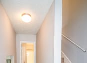 Thumbnail 5 of 36 - an empty basement with carpeted stairs and a hallway with a white door