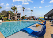 Thumbnail 12 of 20 - A pool with blue water and a yellow sun lounger.