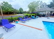 Thumbnail 26 of 47 - A poolside area with blue lounge chairs and a small pool.