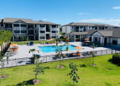 Thumbnail 18 of 23 - an aerial view of a swimming pool with apartments in the background