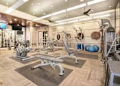 Thumbnail 13 of 20 - A gym with a variety of equipment including treadmills, weights, and exercise balls.