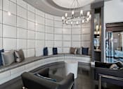 Thumbnail 20 of 20 - A modern living room with a curved bench and a chandelier.