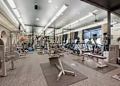 Thumbnail 14 of 20 - A gym with a variety of equipment including weights and cardio machines.