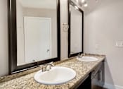 Thumbnail 10 of 20 - A bathroom with a sink and mirrors.