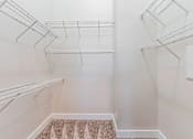 Thumbnail 11 of 20 - Empty white walk in closet with shelves.