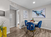 Thumbnail 5 of 32 - A dining room with a table and chairs.