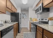 Thumbnail 3 of 32 - A kitchen with black appliances and wooden cabinets.