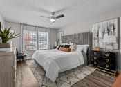 Thumbnail 6 of 32 - A bedroom with a large bed and a ceiling fan.
