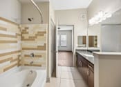 Thumbnail 11 of 38 - A bathroom with a tiled shower and a bathtub.