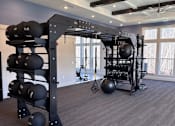 Thumbnail 18 of 41 - A home gym with a weight rack and a ceiling fan.