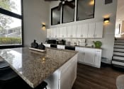 Thumbnail 22 of 36 - a kitchen with white cabinets and a granite counter top