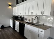 Thumbnail 25 of 36 - a kitchen with white cabinets and a granite counter top