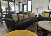 Thumbnail 29 of 36 - a living room with a black couch and yellow pillows