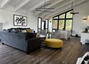 Thumbnail 33 of 36 - a living room with a gray couch and a yellow ottoman