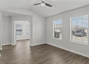 Thumbnail 29 of 29 - an empty living room with a ceiling fan and three windows