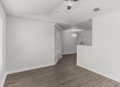 Thumbnail 28 of 29 - an empty living room and kitchen with white walls and wood flooring