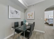 Thumbnail 5 of 32 - a dining area with a glass table and four black chairs