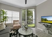 Thumbnail 13 of 32 - a living room with a sliding glass door leading to a balcony