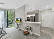 Thumbnail 4 of 32 - a spacious living room with a kitchen in the background