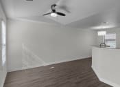 Thumbnail 18 of 29 - an empty living room with white walls and a ceiling fan
