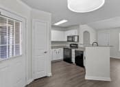 Thumbnail 20 of 29 - an empty kitchen with white cabinets and a black stove and