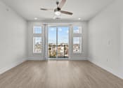 Thumbnail 24 of 24 - A room with a ceiling fan and sliding glass doors.