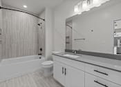 Thumbnail 12 of 24 - A modern bathroom with a white tub, sink, and toilet.