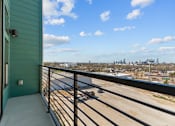 Thumbnail 18 of 24 - A balcony with a view of a city skyline.