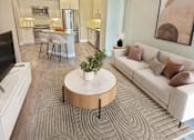 Thumbnail 20 of 44 - A modern living room with a white sofa and a wooden coffee table.