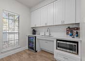 Thumbnail 26 of 30 - A kitchen with white cabinets and a black fridge.