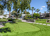 Thumbnail 10 of 29 - A green lawn with a white sign and a fence in the background.