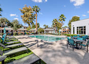 Thumbnail 5 of 29 - A pool area with sun loungers and a table.