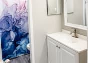 Thumbnail 11 of 19 - a bathroom with a sink and a mirror and a shower curtain