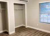 Thumbnail 13 of 19 - an empty bedroom with a closet and a ceiling fan with wood flooring