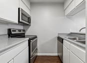 Thumbnail 4 of 22 - A kitchen with white cabinets and a black stove top oven.