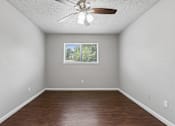 Thumbnail 12 of 22 - Empty room with a ceiling fan and a window.