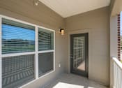 Thumbnail 7 of 17 - A balcony with a door and a window.